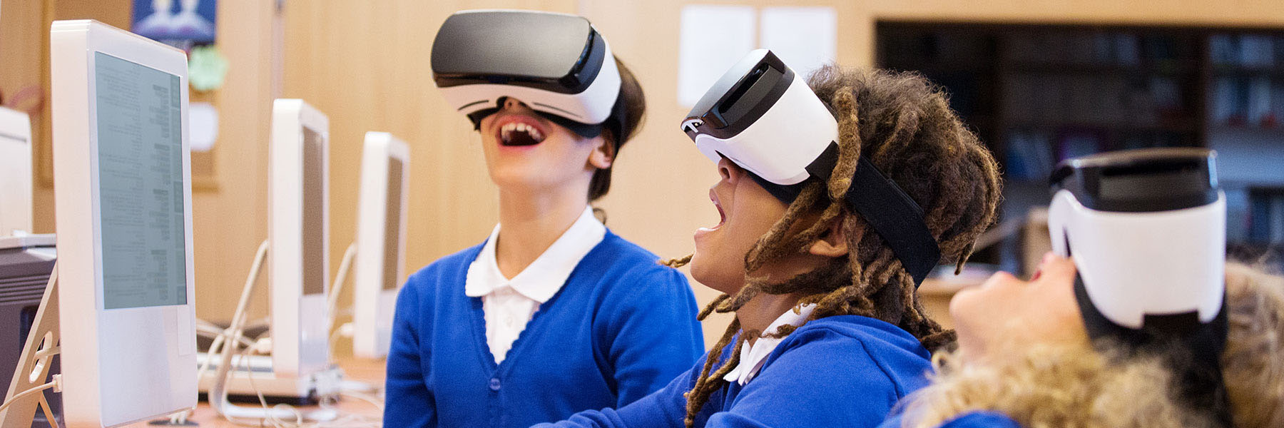 Kids playing with virtual reality headsets in a computer lab