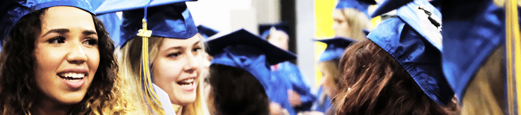 female SFCC graduates in caps and gowns at their graduation ceremony