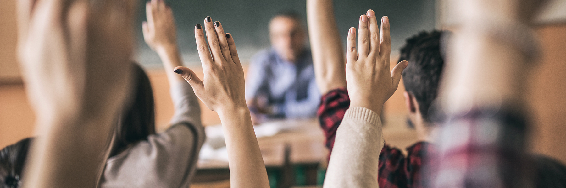 Hands in the air in a classroom
