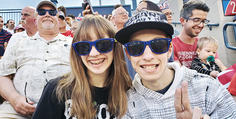 Two kids wearing our CCS Foundation sunglasses at an Alumni Event