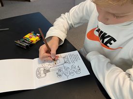 Boy coloring in a page of a coloring book